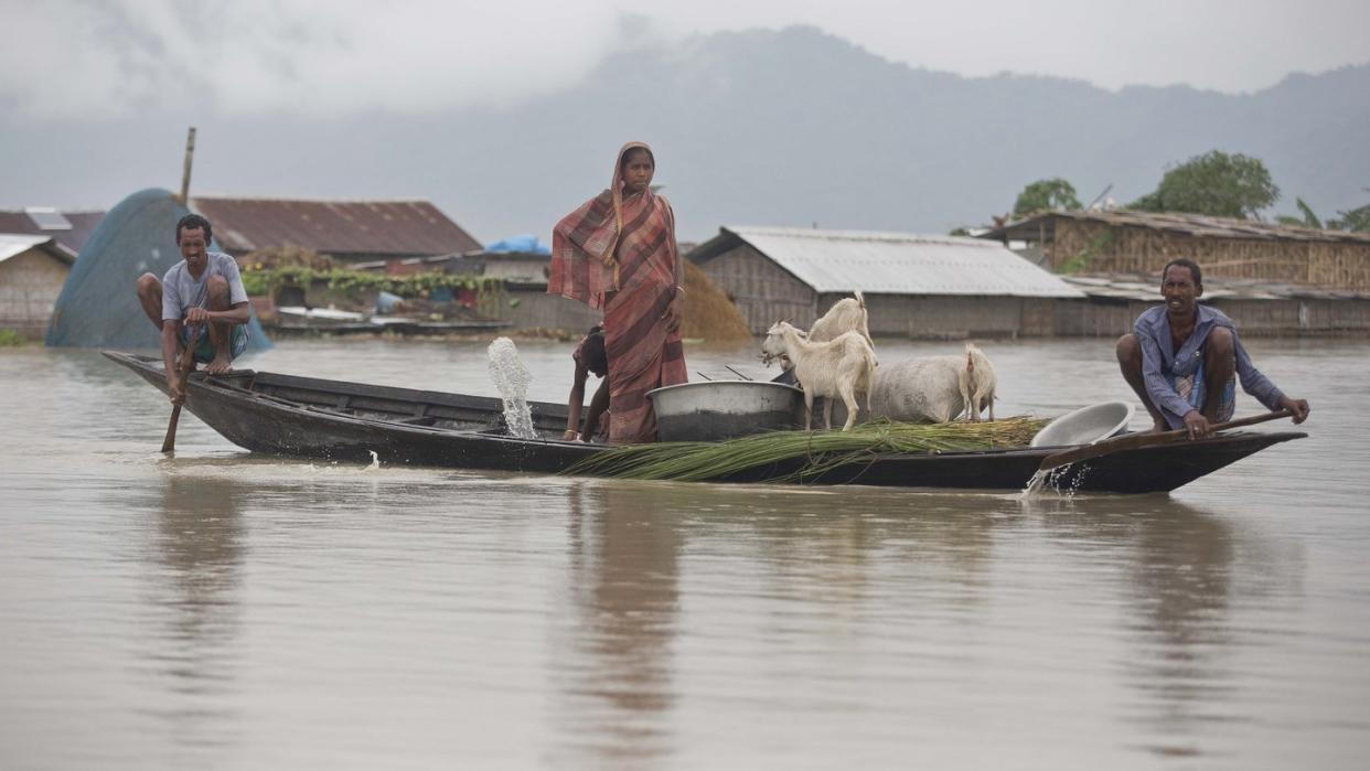 Dorfbewohner fahren mit einem Boot entlang des Flusses Brahmaputra. Heftiger Monsunregen und Gewitter haben in Südasien zahlreiche Überschwemmungen ausgelöst. Foto: Anupam Nath/AP