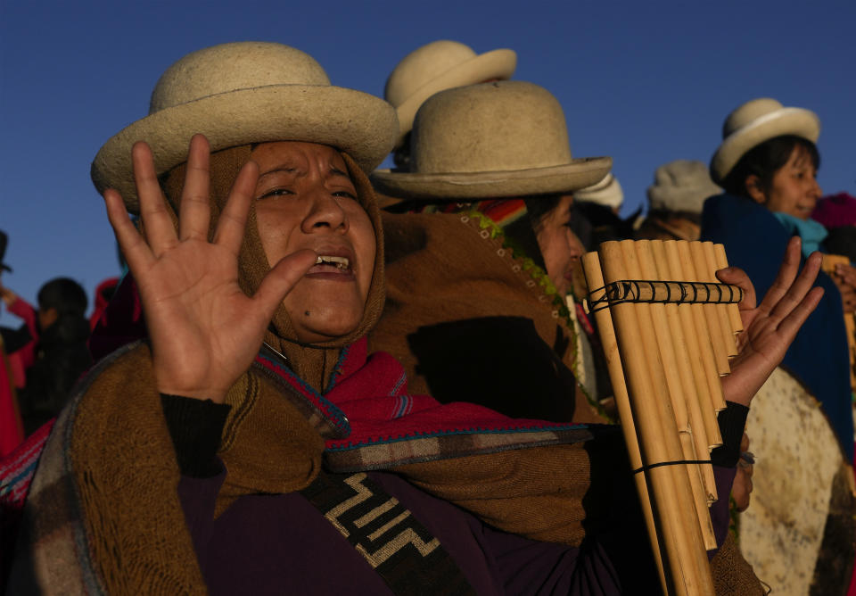 Una mujer indígena aymara recibe los primeros rayos de sol en un ritual de Año Nuevo en la montaña Murmutani en las afueras de Hampaturi, Bolivia, la madrugada del miércoles 21 de junio de 2023. (AP Foto/Juan Karita)