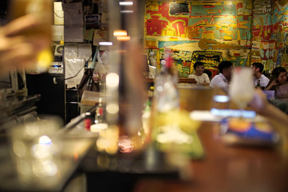 In this Oct. 7, 2020 photo, customers sit at Club 71 in Hong Kong. The bar known as a gathering place for pro-democracy activists and intellectuals is closing. (AP Photo/Vincent Yu)