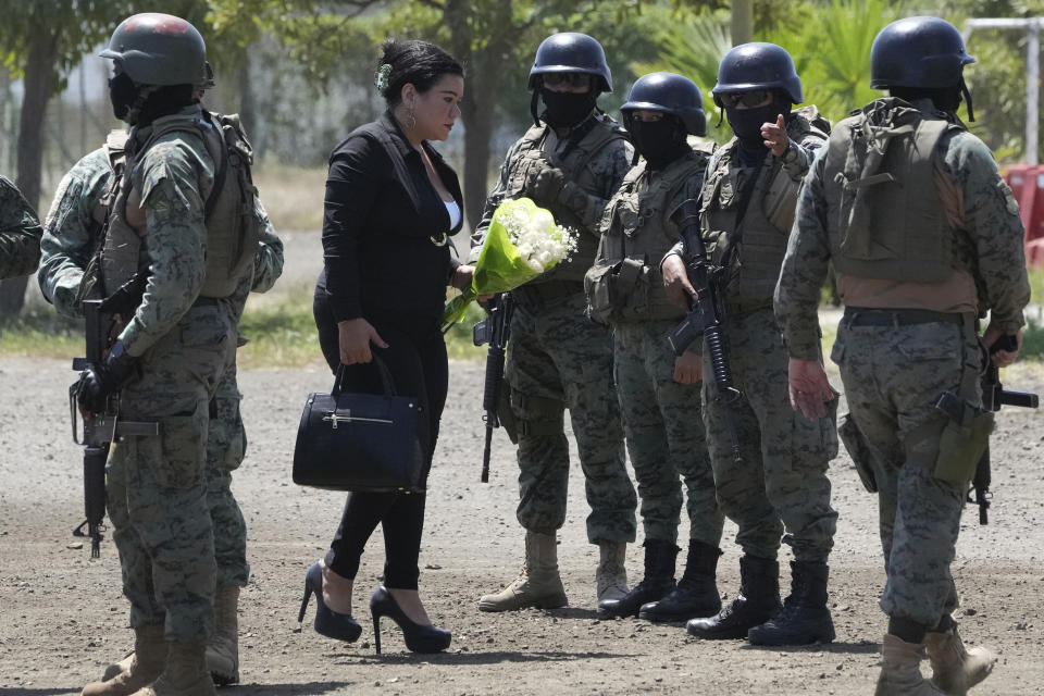 FILE - A woman carries a bouquet of flowers to the funeral of Mayor Agustin Intriago, who was killed by unknown assailants over the weekend, in Manta, Ecuador, July 24, 2023. Ecuador's President Guillermo Lasso decreed a state of emergency in Manabi and El Oro provinces, citing the murder of Mayor Intriago as one of the causes of the decree. (AP Photo/Dolores Ochoa, File)