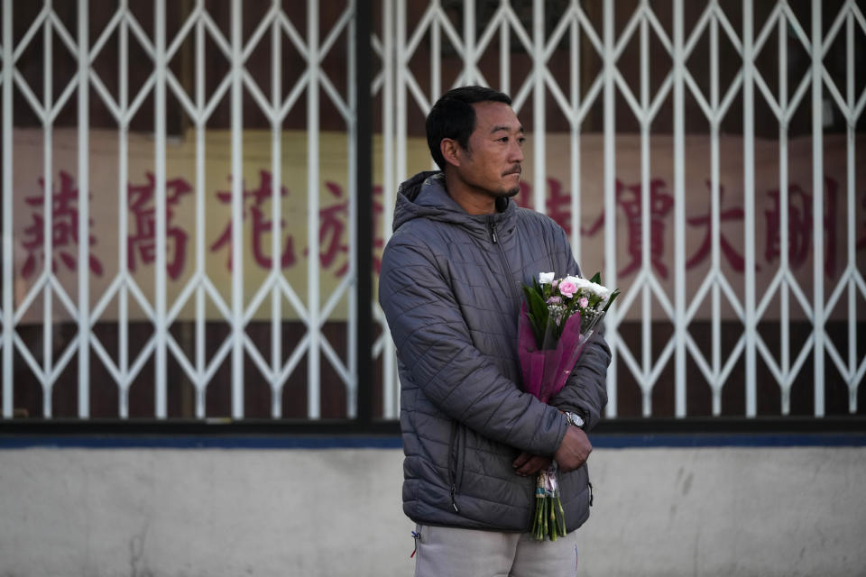 Hunter Zhao, 41, holds flowers to honor the victims killed in Saturday's mass shooting in Monterey Park, Calif., Sunday. (Jae C. Hong/AP)