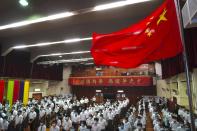 Students attend a flag raising ceremony during the National Security Education Day at a secondary school, in Hong Kong, Thursday, April 15, 2021. Beijing's top official in Hong Kong on Thursday warned foreign forces not to interfere with the "bottom line" of national security in Hong Kong, threatening retaliation even amid ongoing tensions between China and Western powers. (AP Photo/Kin Cheung)