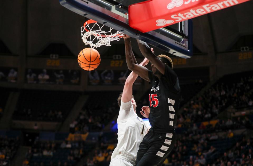 Jan 31, 2024; Morgantown, West Virginia, USA; Cincinnati Bearcats forward Aziz Bandaogo (55) dunks the ball over West Virginia Mountaineers forward Quinn Slazinski (11) during the first half at WVU Coliseum.