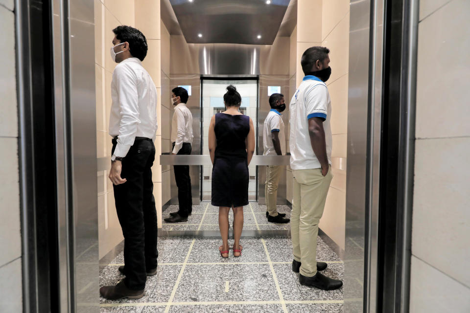 People practice social distancing inside an elevator in Colombo, Sri Lanka, on May 11. (Photo: Dinuka Liyanawatte / Reuters)