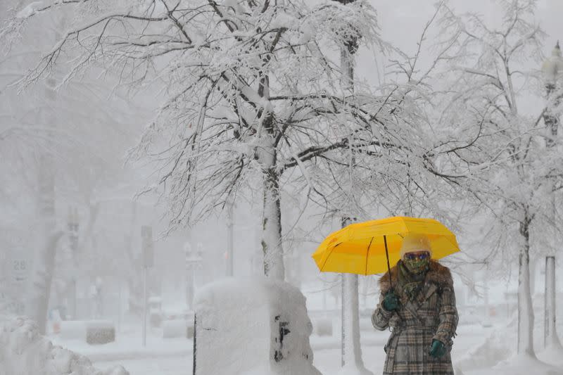 A pedestrian walks through the falling snow in Boston