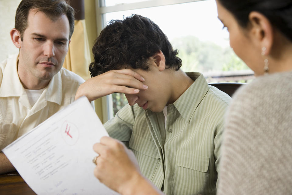 A young man being scolded for an "F"