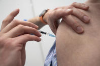 An employee of the Tuebingen Vaccination Centre inoculates a dose of Biontech vaccine in the Paul Horn Arena in Tuebingen, Germany, Wednesday, April 21, 2021. Countries in the European Union have ramped up the vaccination after sluggish start. The uptick comes as countries across Europe also grapple with a rise in infections that has pushed the EU’s overall number of confirmed cases close to 30 million. (Marijan Murat/dpa via AP)