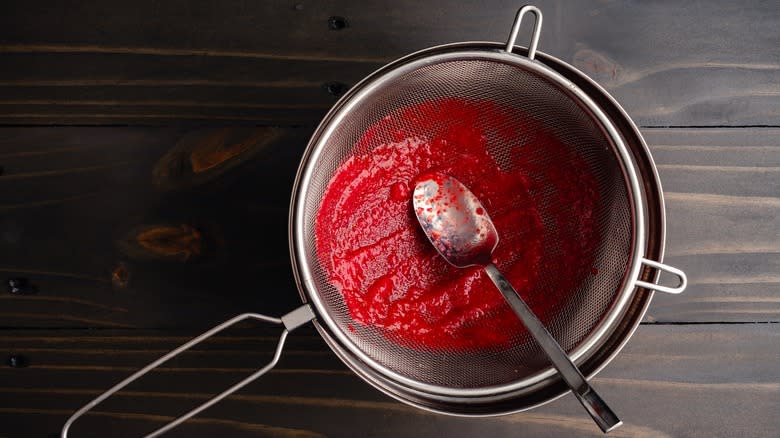 strawberry purée in strainer