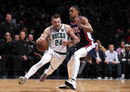Milwaukee Bucks guard Pat Connaughton (24) drives to the basket against Brooklyn Nets forward Nic Claxton (33) during the first half of an NBA basketball game Thursday, March 31, 2022, in New York. (AP Photo/Noah K. Murray)