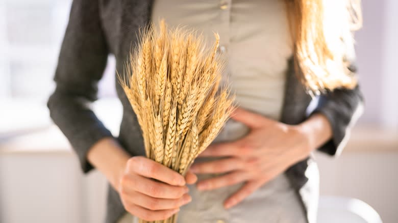 Person with stomach pain holding wheat