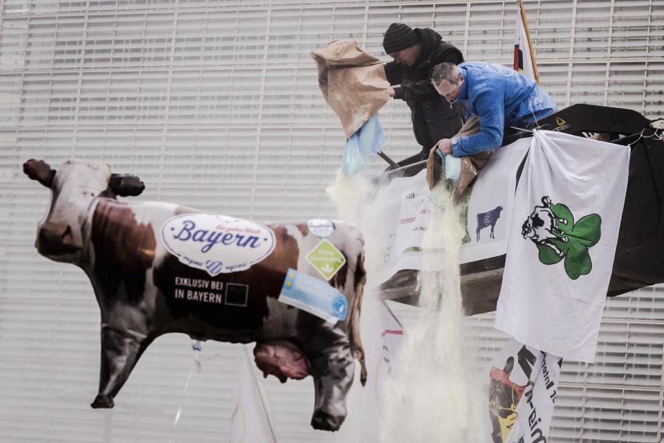 European dairy farmers spray the EU Council building with milk powder to protest the crisis in their sector, in Brussels on Monday, Jan. 23, 2017. The sector has been hit with sagging prices and production costs squeezing profits to the extent that has driven many farmers to the brink of bankruptcy. The EU's executive Commission has approved some support measures over the past year, but the farmers fear that releasing more milk powder on the market would further complicate their plight. (AP Photo/Geert Vanden Wijngaert)