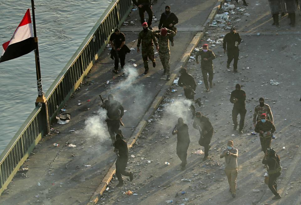 Security forces fire tear gas during a demonstration in Baghdad, Iraq, Saturday, Oct. 26, 2019. Iraqi protesters converged on a central square in the capital Baghdad on Saturday as security forces erected blast walls to prevent them from reaching a heavily fortified government area after a day of violence that killed scores. (AP Photo/Hadi Mizban)