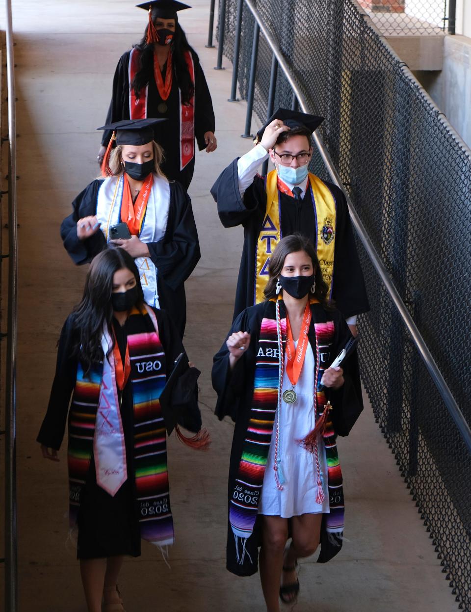 Graduates head to the field May 8, 2021, at Oklahoma State University's first in-person graduation ceremony since December 2019 and the first time in Boone Pickens Stadium since 2006.