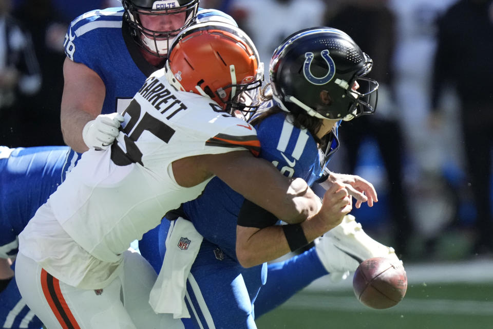 Indianapolis Colts quarterback Gardner Minshew (10) fumbles as he is sacked by Cleveland Browns defensive end Myles Garrett (95) during the first half of an NFL football game, Sunday, Oct. 22, 2023, in Indianapolis. (AP Photo/AJ Mast)