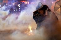 Protesters retreat after police used tear gas Friday, Oct. 9, 2020, in Wauwatosa, Wis. On Wednesday, District Attorney John Chisholm declined to charge Wauwatosa police Officer Joseph Mensah in the February fatal shooting of 17-year-old Alvin Cole outside a mall. (AP Photo/Morry Gash)