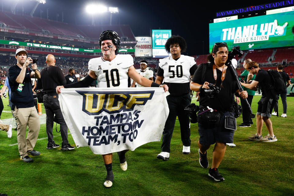 Nov 26, 2022; Tampa, Florida, USA; UCF Knights quarterback John Rhys Plume (10) holds a sign after defeating the South Florida Bulls at Raymond James Stadium. Mandatory Credit: Douglas DeFelice-USA TODAY Sports