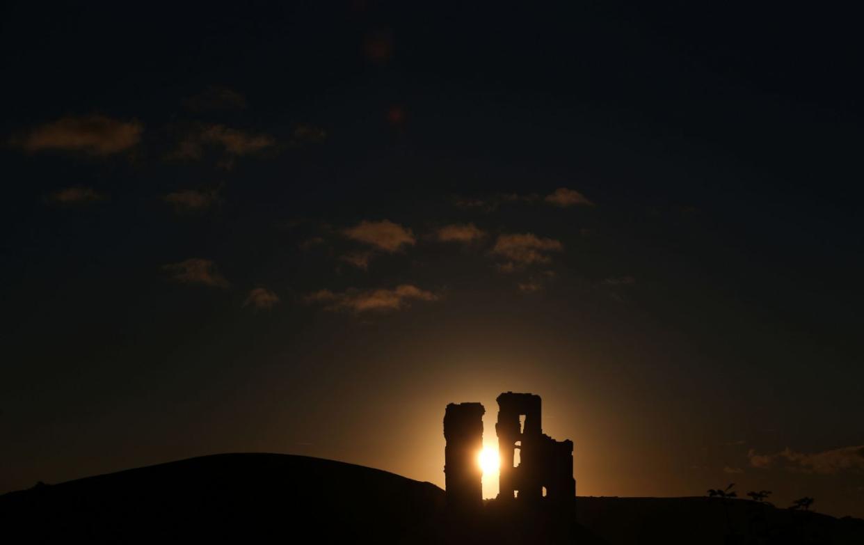 The sun rises behind Corfe Castle  in Dorset (Andrew Matthews/PA)