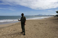 A security guard wearing a protective mask to help curb the spread of the coronavirus as he guards an empty beach in Bali, Indonesia on Friday, May 22, 2020. (AP Photo/Firdia Lisnawati)