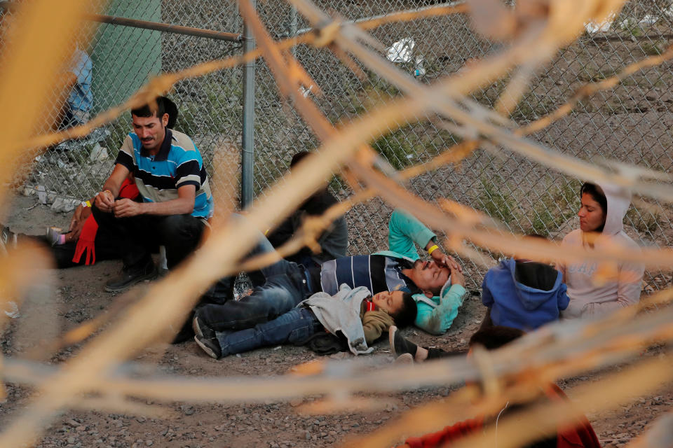 A man and child lie on the ground inside an enclosure, where they are being held by U.S. Customs and Border Protection (CBP), after crossing the border between Mexico and the United States illegally and turning themselves in to request asylum, in El Paso, Texas, U.S., March 29, 2019.  (Photo: Lucas Jackson/Reuters)