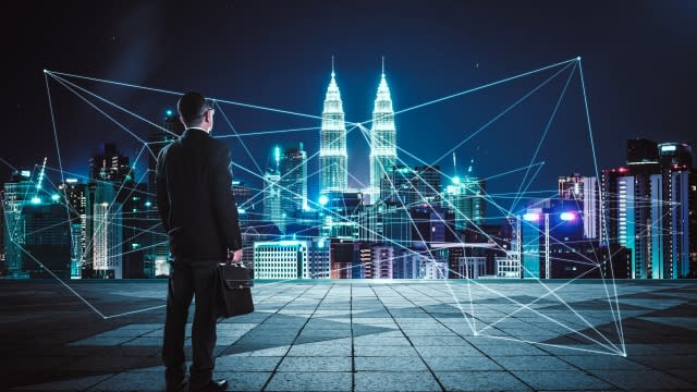 Businessman looking at city with network