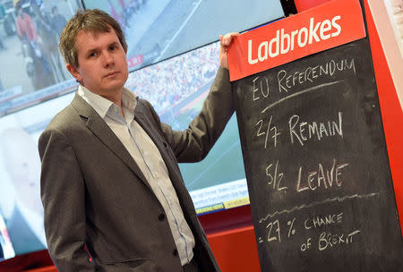 Matthew Shaddick, Head of Political Betting at Ladbrokes poses as he writes on a chalk board at a branch of Ladbrokes in central London, Britain, May 17, 2016. REUTERS/Toby Melville