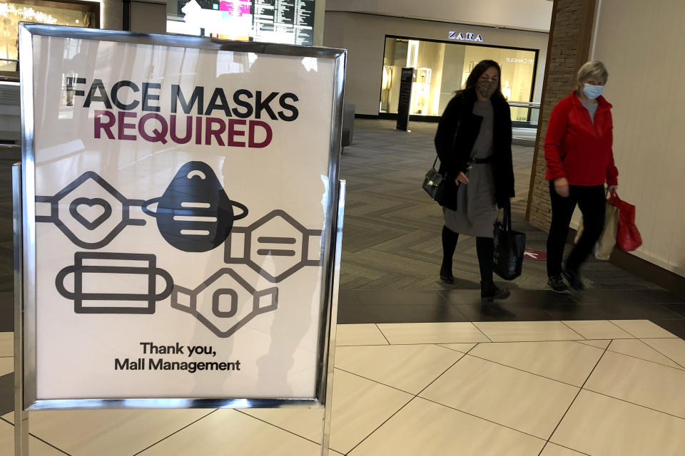 FILE - In this Nov. 13, 2020, file photo, a "Face masks required" sign is displayed at a shopping center in Schaumburg, Ill. States in the U.S. are renewing their push for more federal money to deal with the fallout from the coronavirus outbreak and to help them distribute a vaccine when one becomes widely available sometime in 2021. (AP Photo/Nam Y. Huh, File)