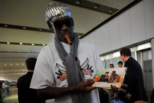 Dennis Rodman shows pictures of him reportedly with North Korea's Kim Jong-Un to the media at the Beijing airport on September 7, 2013. Rodman returned to China from Pyongyang Saturday after a five-day trip when he met the North Korean leader, but without jailed American Kenneth Bae