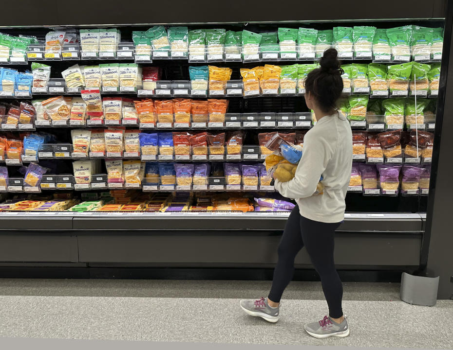 ARQUIVO - Um comprador examina vitrines de queijos em uma loja Target em 4 de outubro de 2023, em Sheridan, Colorado. A inflação está a cair ligeiramente, mas os preços dos produtos alimentares permanecem elevados. (Foto AP / David Zalubowski, Arquivo)