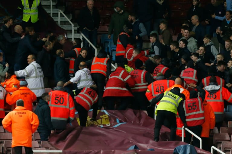 Stewards intervene as the home and away fans confront each other during the match between West Ham and Manchester City at Upton Park