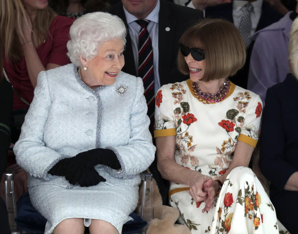 ARCHIVO – La reina Isabel II de Gran Bretaña sentada junto a la editora de moda de Vogue Anna Wintour mientras miran el desfile de Richard Quinn antes de entregarle el primer Premio Reina Isabel II al Diseño Británico en Londres el 20 de febrero de 2018. (Yui Mok/Pool photo via AP)