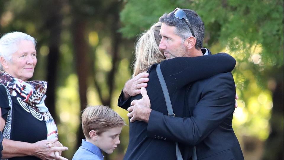 Aaron Cockman embraces a loved one at the funeral of his four children who were killed near Margaret River. Source: AAP