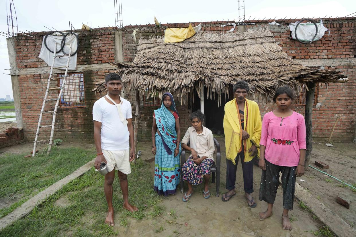 Khushboo Bind, center, sits for a photograph with her family members after she was injured by lightning that killed her sister-in-law, also called Khusboo, in a paddy field on June 25, in front of their house at Piparaon village on the outskirts of Prayagraj, in the northern Indian state of Uttar Pradesh, Thursday, July 28, 2022. Seven people, mostly farmers, were killed by lightning in a village in India's northern Uttar Pradesh state, police said Thursday, bringing the death toll by lightning to 49 people in the state this week. (AP Photo/Rajesh Kumar Singh)