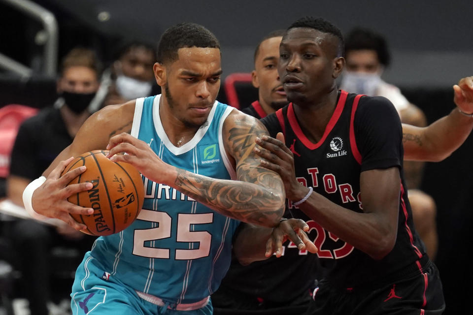 Charlotte Hornets forward P.J. Washington (25) runs into Toronto Raptors forward Chris Boucher (25, right) during the first half of an NBA basketball game Saturday, Jan. 16, 2021, in Tampa, Fla. (AP Photo/Chris O'Meara)