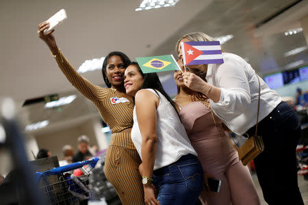 Cuban doctors take a selfie as they return to their home, after criticism by Brazil's President-elect Jair Bolsonaro prompted Cuba's government to sever a cooperation agreement, in Brasilia, Brazil November 22, 2018. REUTERS/Adriano Machado