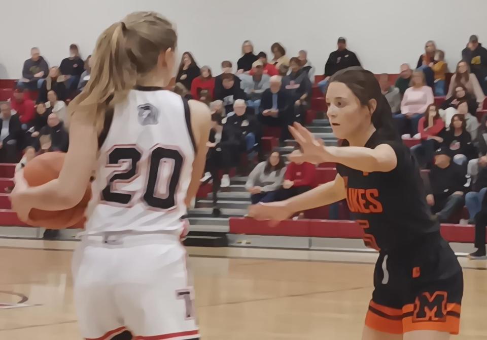 Tusky Valley's Maleah Dillon, left, cradles in a pass as Marlington's Ava Clough, right, defends during Saturday's high school girls' basketball game at Tusky Valley High School.