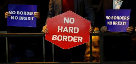 People hold placards as they attend a candlelight vigil on the border between Ireland's Donegal county and Londonderry county in Northern Ireland in Lifford, Ireland