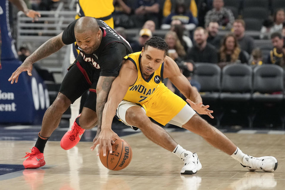 Miami Heat forward P.J. Tucker, left, and Indiana Pacers guard Malcolm Brogdon reach for the ball during the first half of an NBA basketball game in Indianapolis, Friday, Dec. 3, 2021. (AP Photo/AJ Mast)