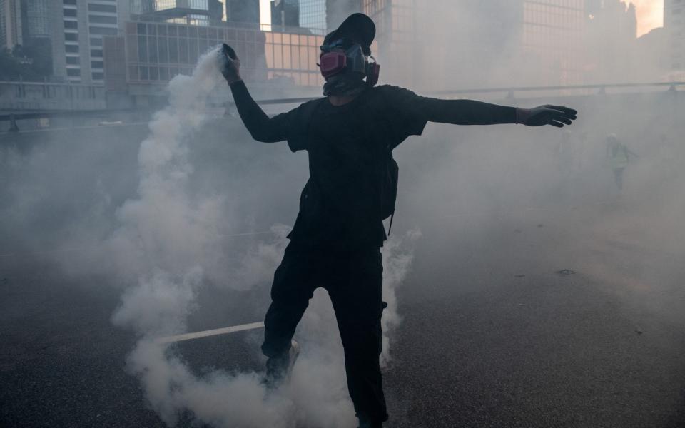 A pro-democracy protester throws a police teargas cartridge back at officers on September 15 - Getty Images AsiaPac