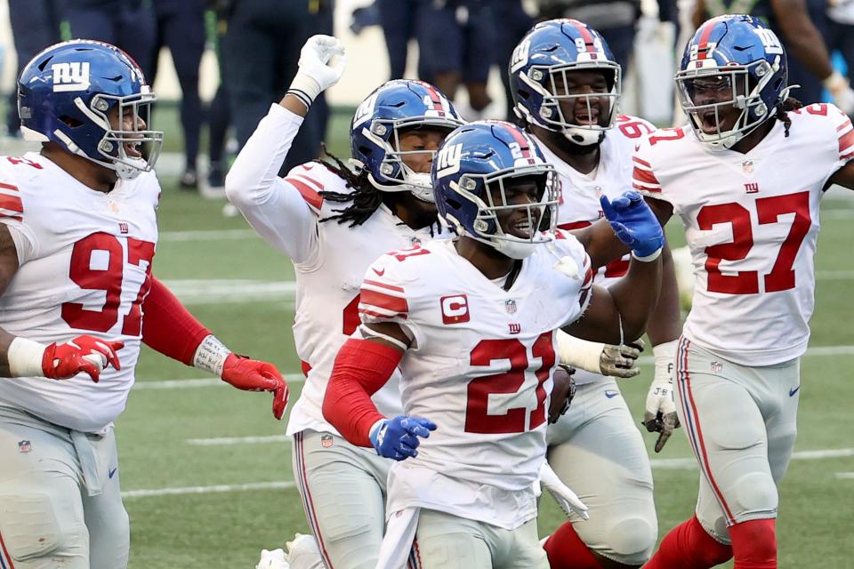 Dexter Lawrence, Jabrill Peppers and Isaac Yiadom of the New York Giants celebrate an interception by Darnay Holmes #30 (not pictured) against the Seattle Seahawks during the fourth quarter in the game at Lumen Field on December 06, 2020 in Seattle, Washington.