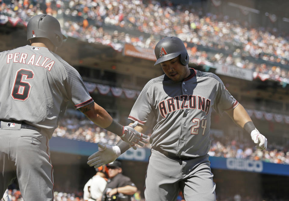 Arizona Diamondbacks' Yasmany Tomas, right, is greeted by teammate David Peralta, left, after hitting a home run off San Francisco Giants starting pitcher Matt Moore in the fifth inning of a baseball game, Monday, April 10, 2017, in San Francisco. (AP Photo/Eric Risberg)