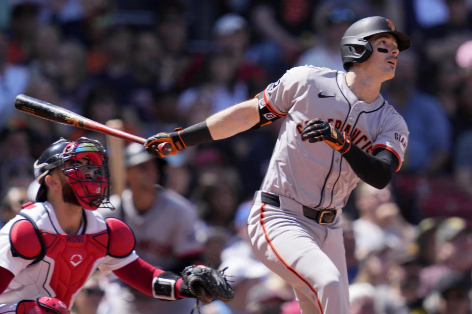 San Francisco Giants' Mike Yastrzemski watches the flight of his solo home run during the third inning of a baseball game at Fenway Park, Thursday, May 2, 2024, in Boston. At left is Boston Red Sox catcher Connor Wong. (AP Photo/Charles Krupa)