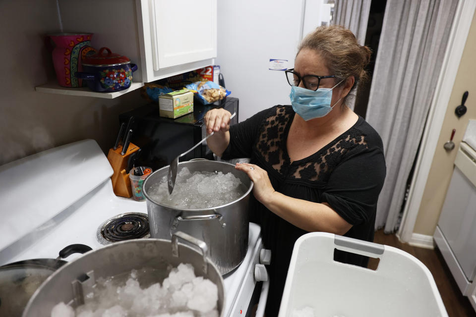 Image: Marie Maybou melts snow on the kitchen stove in Austin, Texas. (Joe Raedle / Getty Images)