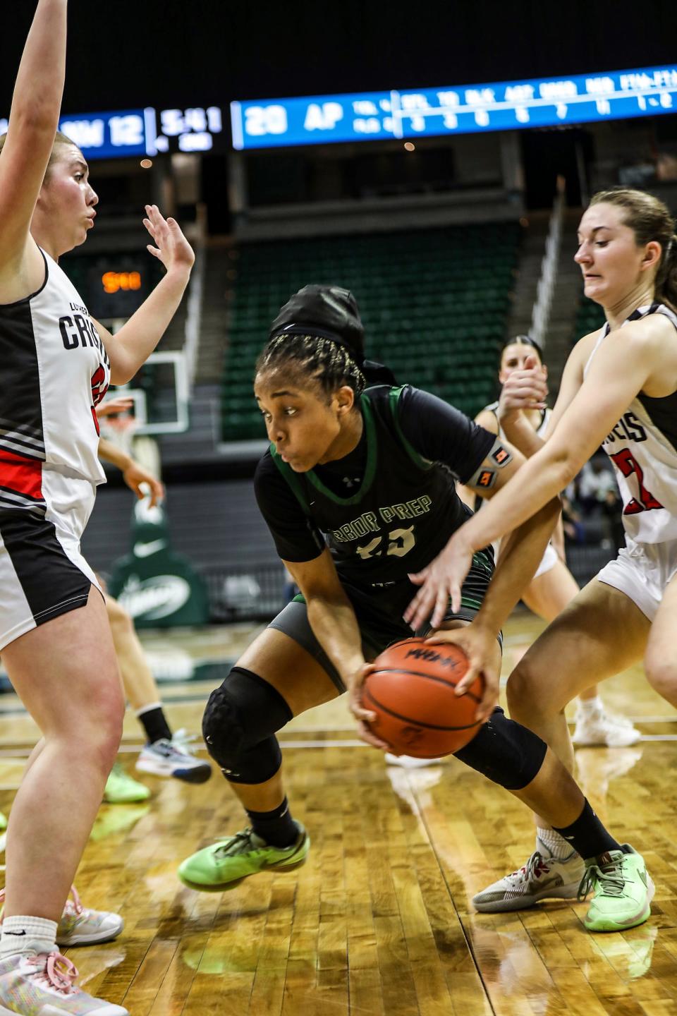 Ypsilanti Arbor Prep’s Stephanie Utomi cuts between Rochester Hills Lutheran NW’s defenders Ashley Cadicamo and Morgan Griswold during Arbor Prep's 52-30 win in the MHSAA girls basketball Division 3 semifinals on Thursday, March 21, 2024, at Breslin Center.