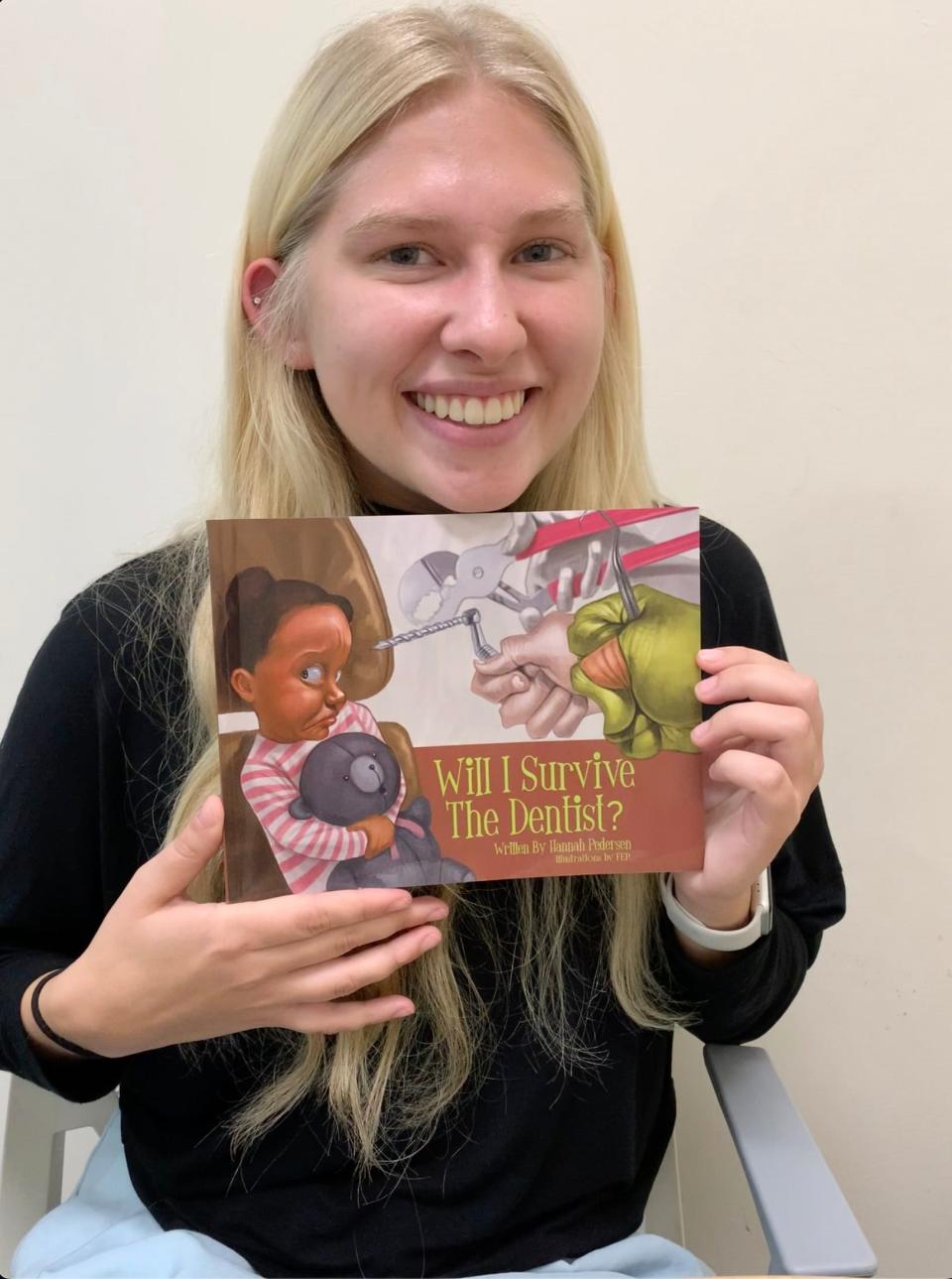 Hannah Rose Pedersen displays her book, "Will I Survive the Dentist?" Pedersen is hoping to be admitted to IUPUI's dentistry school in December.