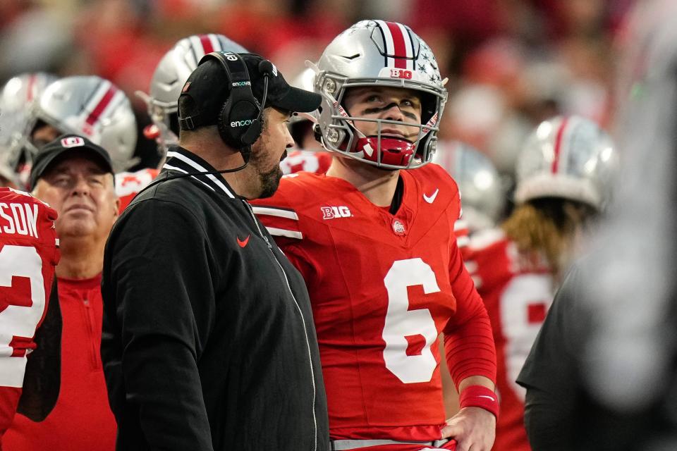 Ohio State coach Ryan Day talks to quarterback Kyle McCord during the first half of the Buckeyes' 37-3 win over Minnesota.