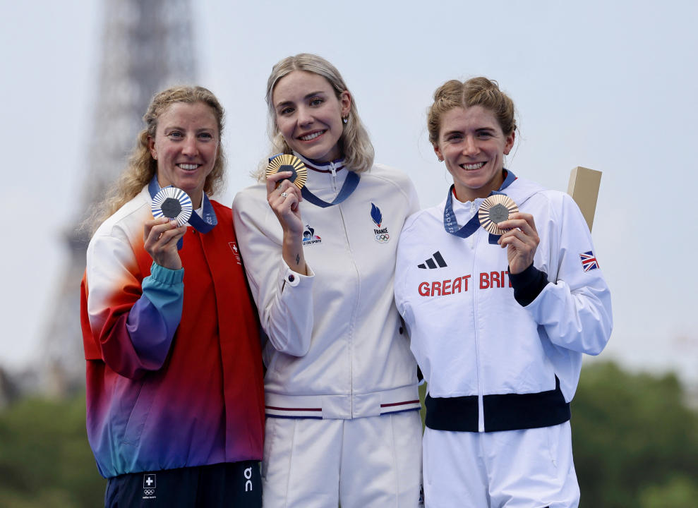 La francesa Cassandre Beaugrand ganadora del oro posa con la suiza Julie Derron ganadora de la medalla de plata y la británica Beth Potter con la medalla de bronce en triatlón REUTERS/Lisa Leutner