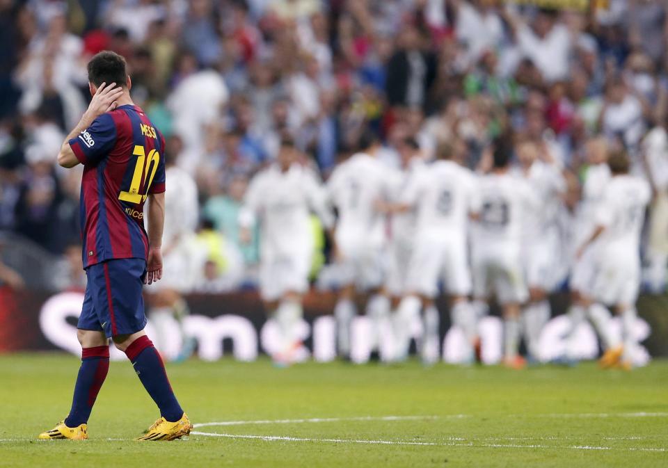 Barcelona's Lionel Messi (L) looks on as Real Madrid's players celebrate their second goal during their Spanish first division "Clasico" soccer match at the Santiago Bernabeu stadium in Madrid October 25, 2014. REUTERS/Juan Medina (SPAIN - Tags: SOCCER SPORT)