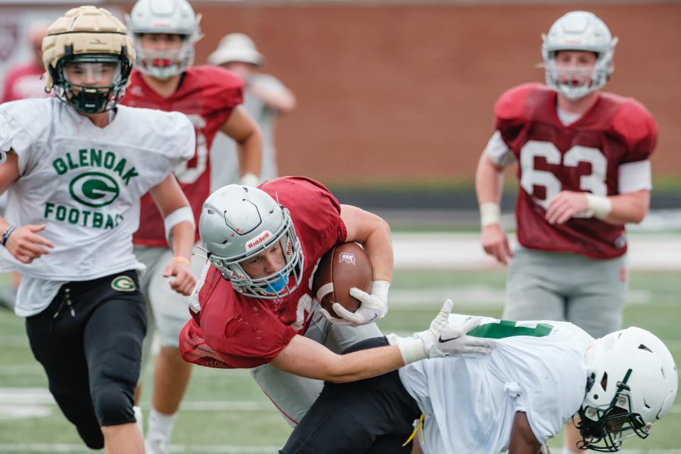 Dover's Mitchell Martin evades a GlenOak tackle during their scrimmage, Saturday, Aug. 6 at Crater Stadium.
