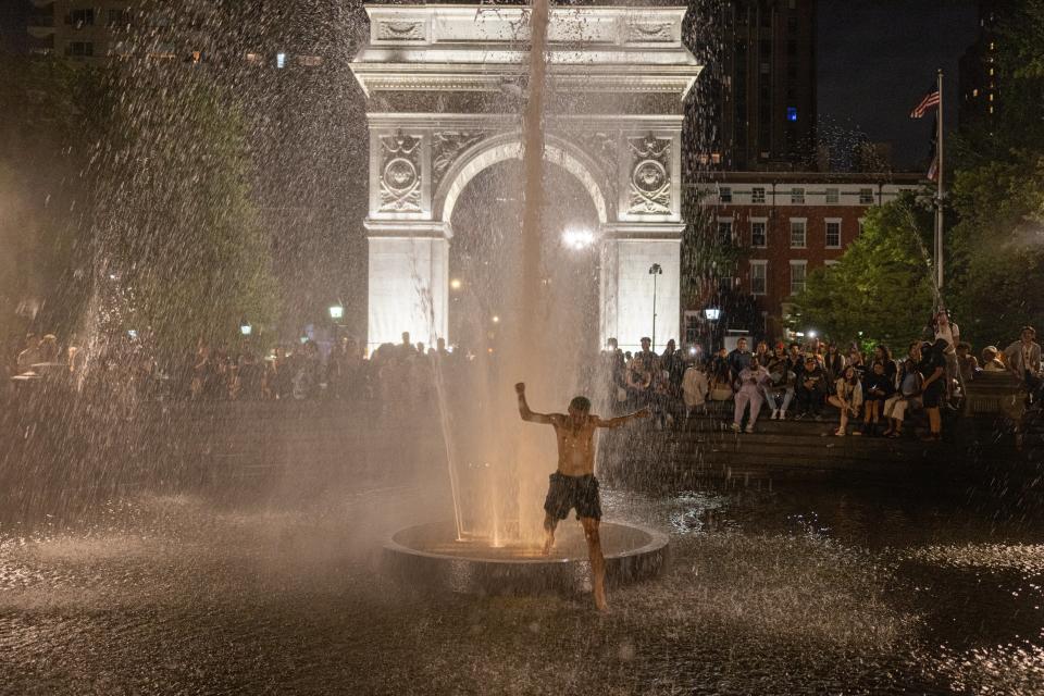Partygoers in Washington Square Park run through the fountain drawing cheers from onlookers on June 18, 2021 in New York City (Getty Images)