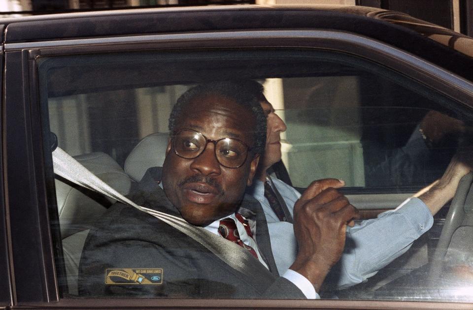 Supreme Court nominee Clarence Thomas looks out the window of a car as he leaves his Alexandria, Virginia home, Oct. 9, 1991.